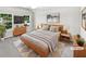 Staged main bedroom with large windows, neutral walls, and modern wood furniture at 2438 Suwanee Pointe Dr, Lawrenceville, GA 30043