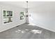Inviting dining room with modern chandelier, plush carpeting, and plenty of natural light at 2438 Suwanee Pointe Dr, Lawrenceville, GA 30043