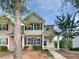 Charming townhome featuring manicured landscaping, neutral siding, dark shutters and a covered front porch at 2438 Suwanee Pointe Dr, Lawrenceville, GA 30043