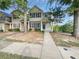 Charming townhome featuring manicured landscaping, neutral siding, dark shutters and a covered front porch at 2438 Suwanee Pointe Dr, Lawrenceville, GA 30043