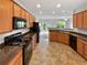 Bright kitchen with wooden cabinets, black appliances, and tiled flooring at 2438 Suwanee Pointe Dr, Lawrenceville, GA 30043