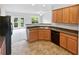 Open kitchen with a view into a light-filled room and a stainless steel sink with wooden cabinets at 2438 Suwanee Pointe Dr, Lawrenceville, GA 30043