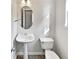 Cozy powder room with a pedestal sink, modern faucet, and a stylish mirror at 2438 Suwanee Pointe Dr, Lawrenceville, GA 30043