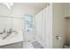 Bright bathroom featuring white tile floors, a window, and a shower with a decorative curtain at 350 Eagle Tiff Dr, Sugar Hill, GA 30518