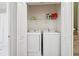 Convenient laundry room featuring a white washer and dryer set with shelving at 350 Eagle Tiff Dr, Sugar Hill, GA 30518