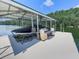 Covered boat dock featuring boat lift, seating area, and ladder access to the lake at 7560 Island Mill Rd, Acworth, GA 30102