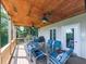Covered outdoor deck with ceiling fans, dining area, and lake view at 7560 Island Mill Rd, Acworth, GA 30102
