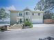 Elegant home featuring manicured landscaping, stone steps, and a well-lit driveway leading to an attached two car garage at 7560 Island Mill Rd, Acworth, GA 30102