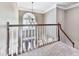 View of a carpeted stairway and a chandeliered front entry visible from the second floor at 7560 Island Mill Rd, Acworth, GA 30102