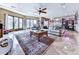 Open-concept living room featuring a ceiling fan, large windows, and comfortable seating area at 7560 Island Mill Rd, Acworth, GA 30102