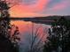 Stunning sunset reflecting on the lake, framed by silhouetted trees at 7560 Island Mill Rd, Acworth, GA 30102