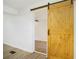 Bright room with a natural wood sliding barn door and modern wood grain vinyl plank flooring at 2005 Simmons Ave, Atlanta, GA 30337