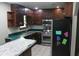 The kitchen features wood cabinets, stainless steel appliances, a tile floor and green countertops at 2842 Jordan Forest Trail Northwest, Lawrenceville, GA 30044