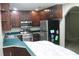 A classic kitchen with dark wood cabinets, stainless steel appliances, and green countertops at 2842 Jordan Forest Trail Northwest, Lawrenceville, GA 30044
