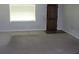 Empty living room with neutral carpet, large window, and a view of a solid wood door at 2842 Jordan Forest Trail Northwest, Lawrenceville, GA 30044