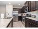 This kitchen has stainless appliances, granite countertops and dark wood cabinets with modern finishes at 111 Point View Dr, Canton, GA 30114