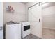 Laundry room with a washer, dryer, storage shelf, and a barn door at 111 Point View Dr, Canton, GA 30114