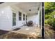 Covered patio area with a dining set, white siding, green landscaping, and a drain pipe at 111 Point View Dr, Canton, GA 30114