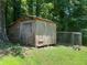 Old shed and caged area with mature trees and underbrush at 2832 Jordan Forest Trail Northwest, Lawrenceville, GA 30044