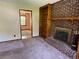 View of brick fireplace with bookshelves, carpet flooring, and view to adjacent room at 2832 Jordan Forest Trail Northwest, Lawrenceville, GA 30044