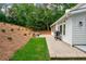 Backyard view featuring a grill, brick pavers, landscaped hillside, and lush trees surrounding the area at 3375 Rivendell Ct, Roswell, GA 30075