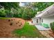 Serene backyard featuring a landscaped hill, a patio with green chairs, and the back of the home at 3375 Rivendell Ct, Roswell, GA 30075
