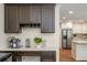 Butler's pantry with dark wood cabinetry, coffee station, and open access to the kitchen at 3375 Rivendell Ct, Roswell, GA 30075