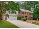 Two-story brick home with a two-car garage, lush landscaping, and inviting curb appeal at 3375 Rivendell Ct, Roswell, GA 30075