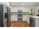 Modern kitchen featuring stainless steel appliances, white cabinetry, and hardwood floors at 3375 Rivendell Ct, Roswell, GA 30075