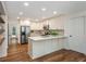 A bright kitchen featuring hardwood floors, an island, stainless appliances and white cabinetry at 3375 Rivendell Ct, Roswell, GA 30075