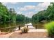 Picturesque view of the lake from a wooden deck with blooming flowers at 3375 Rivendell Ct, Roswell, GA 30075