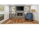 Cozy living room features fireplace with grey brick surround, built-in shelving, and wood flooring at 3375 Rivendell Ct, Roswell, GA 30075