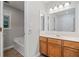 Bathroom with a vanity, sink, large mirror and tub/shower, all illuminated by modern lighting at 3997 Paloverde Nw Dr, Kennesaw, GA 30144