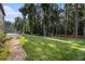 This backyard has a stone pathway leading to the manicured lawn and forest at 5086 N Woodbridge Trl, Stone Mountain, GA 30088