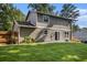 Back exterior of home with well-kept lawn and wooded area in the background at 5086 N Woodbridge Trl, Stone Mountain, GA 30088
