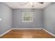Bedroom with hardwood floors, neutral paint, and a bright window offering ample natural light at 5086 N Woodbridge Trl, Stone Mountain, GA 30088