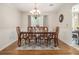 Formal dining room featuring a classic chandelier, wainscoting details, and a view into the adjoining room at 5086 N Woodbridge Trl, Stone Mountain, GA 30088