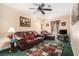 Comfortable living room with plush seating, a ceiling fan, and a decorative rug on top of lush green carpet at 5086 N Woodbridge Trl, Stone Mountain, GA 30088