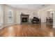 Spacious living room with hardwood floors, a cozy fireplace, and an open view into the adjacent dining area at 5086 N Woodbridge Trl, Stone Mountain, GA 30088