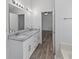 Bathroom featuring double sink vanity, granite countertop, and a decorative vanity mirror at 1644 Royal Ives Dr, Lawrenceville, GA 30045