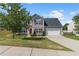 Charming two-story home featuring a well-manicured lawn, gray siding, and a two-car garage on a sunny day at 1644 Royal Ives Dr, Lawrenceville, GA 30045