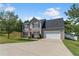 Inviting home with gray siding, dark shutters, a two-car garage, and a spacious driveway nestled on a lush green lawn at 1644 Royal Ives Dr, Lawrenceville, GA 30045