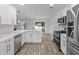 Bright kitchen features stainless steel appliances, white cabinets, and views to the backyard at 1644 Royal Ives Dr, Lawrenceville, GA 30045