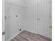 A functional laundry room featuring wood-look flooring and shelving at 1644 Royal Ives Dr, Lawrenceville, GA 30045