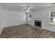 Cozy living room with wood-look floors, fireplace, and a ceiling fan, offering a comfortable and inviting space at 1644 Royal Ives Dr, Lawrenceville, GA 30045
