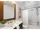Bathroom features a shower-tub combo, white vanity, framed mirror and modern art at 1772 Ridgewood Ne Dr, Atlanta, GA 30307