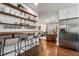 Stylish kitchen with open shelving, breakfast bar seating, stainless steel refrigerator, and hardwood floors at 1772 Ridgewood Ne Dr, Atlanta, GA 30307
