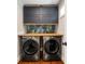 Well-organized laundry room features front-loading washer/dryer, cabinets and decorative wallpaper at 1772 Ridgewood Ne Dr, Atlanta, GA 30307