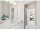 Bathroom featuring a marble countertop, white vanity, and doorway leading to the light-filled bedroom at 310 Braeden Way, Alpharetta, GA 30009