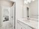Bathroom showcasing a marble vanity, white cabinets, and stylish tile flooring leading to adjacent spaces at 310 Braeden Way, Alpharetta, GA 30009